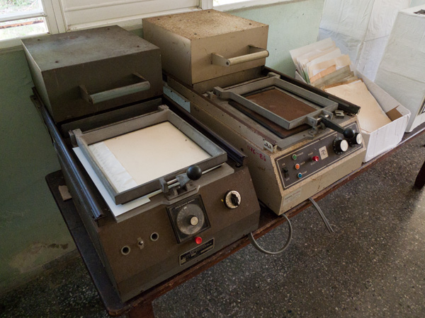 Two thermoform duplicators on a table at the Abel Santamaria School. Next to them is a box full of tactile pictures.